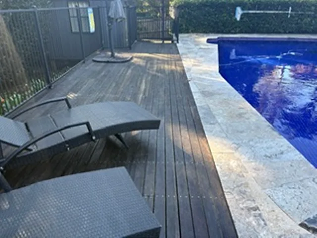 Timber pool deck and travertine pavers beside a backyard pool on the Upper North Shore