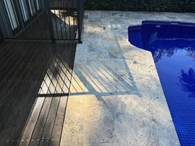 Travertine pavers and timber decking around a backyard pool on the Upper North Shore, ready for a pressure wash